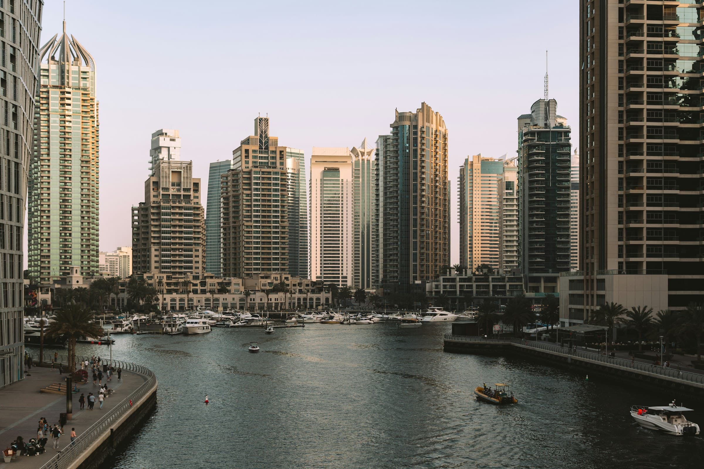 Residential towers and moored yachts along the Dubai Marina waterfront at golden hour